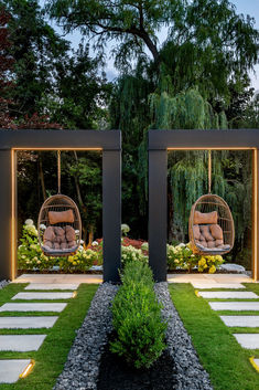 two swings in the middle of a garden with grass and stepping stones on either side