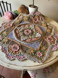 a crocheted doily sitting on top of a table next to a pot holder