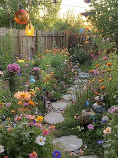 a garden filled with lots of flowers next to a wooden fence and light bulb hanging from the ceiling