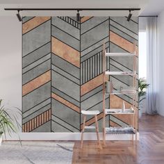 an abstract wall mural in grey and gold with wood strips on the side, along with a plant