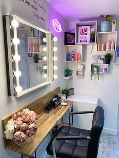 a room with a chair, mirror and lights on the wall next to a desk