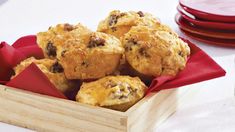 a wooden box filled with muffins sitting on top of a white table cloth