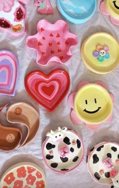 there are many different types of doughnuts on the table with hearts and smiley faces