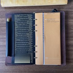 an open notebook sitting on top of a wooden table next to a pencil and ruler