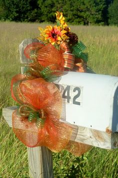 a mailbox decorated with sunflowers and ribbons