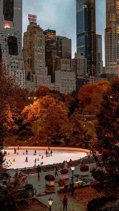 people skating on an ice rink in central park, new york city with the empire building in the background