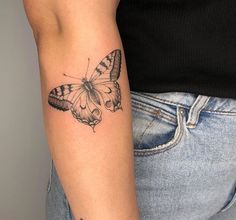 a woman's arm with a butterfly tattoo on the left side of her arm