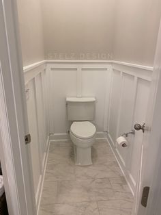 a white toilet sitting in the corner of a bathroom