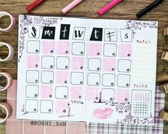 a planner with pink and black stickers on it next to pencils, markers, and other office supplies