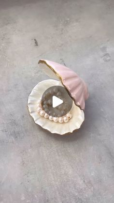 an open shell with pearls on it sitting on the ground