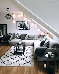 a living room filled with furniture under a slanted ceiling next to a wooden floor