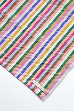 a multicolored striped tie laying on top of a white surface with no background