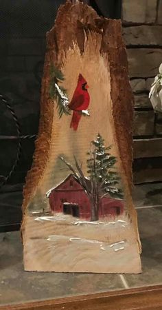 a red cardinal sitting on top of a piece of wood next to a fire place