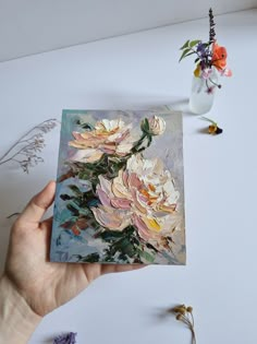 a person holding up a card with flowers on it