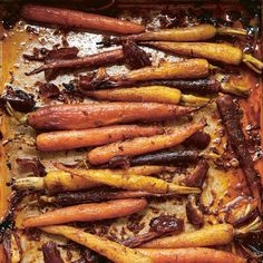 roasted carrots and other vegetables on a baking sheet covered in brown sugar, oil, and seasoning