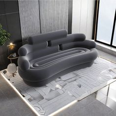 an inflatable couch sitting on top of a white floor next to a potted plant