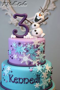 a birthday cake decorated with snowflakes and frosting for the number three on top