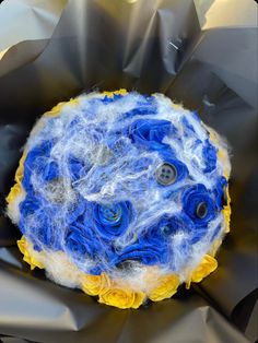 a blue and yellow object sitting on top of a piece of cloth