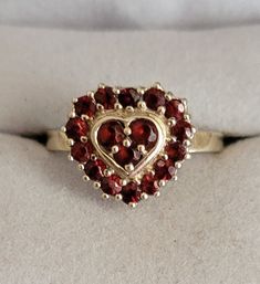 This is a wonderful and well-made garnet ring in the shape of a heart. It contains 17 round faceted and pronged garnet stones. It measures a size 9 and is about a half inch in diameter.  Inside the shank it's stamped 925 and Thailand. Thailand is a major global hub for colored gemstones and is famous for creating handcrafted silver jewelry. Their work is unique and beautiful and has been respected for centuries. In addition to the monetary value, wearing Thai Silver jewelry signifies wealth, status and spirituality. Garnet Heart, Handcrafted Silver Jewelry, Fredericksburg Va, Colored Gemstones, Garnet Ring, Garnet Stone, Garnet Rings, Gemstone Colors, Rings Statement