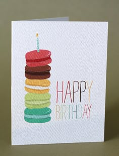 a happy birthday card with a stack of cookies and a lit candle on the top