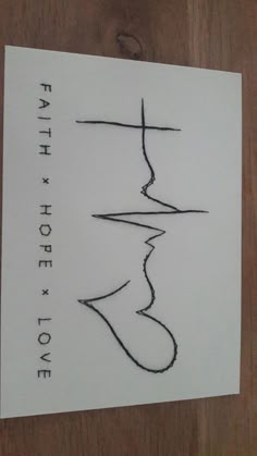 a piece of paper with the words faith above it on top of a wooden table