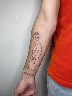 a woman's arm with a tattoo on it that has a drawing of a man