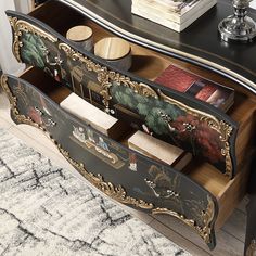 a black and gold decorated dresser with drawers