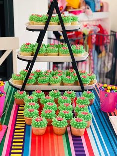 cupcakes are arranged in the shape of a pyramid on a colorful tablecloth