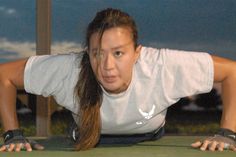 a woman is doing push ups on a tennis court