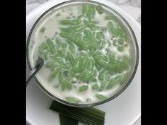 a white plate topped with a green smoothie next to some celery sticks