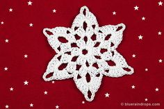 a white crocheted snowflake on a red background