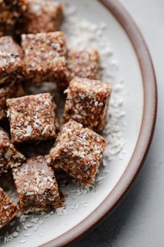 a plate filled with brownies covered in coconut flakes and sprinkles