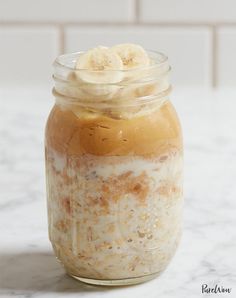 a glass jar filled with oatmeal and bananas on top of a marble counter