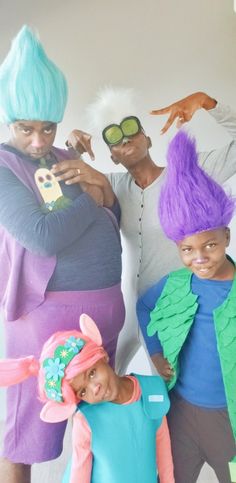 three adults and two children in costumes posing for the camera with their hands on their hipss