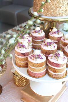 there are many cupcakes on the plate and one is decorated with purple flowers