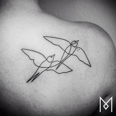 a black and white photo of two birds on the back of a woman's shoulder