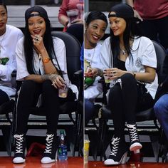 two women sitting next to each other at a basketball game, one in black and the other in white