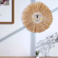 a wall decoration with a lion face on it's side next to a potted plant