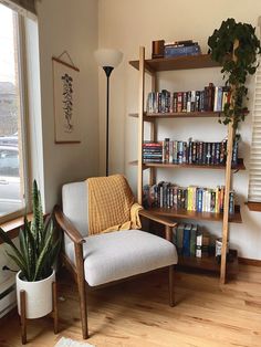 a living room filled with furniture and a book shelf next to a window covered in books