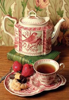 a tea pot sitting on top of a table next to a cup and saucer