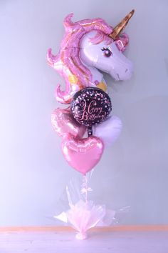 the balloon is shaped like a unicorn and has pink manes on it's head