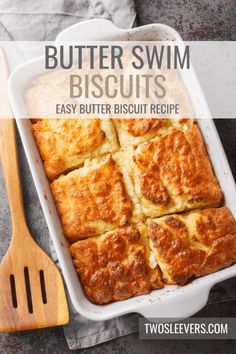 butter swim biscuits in a casserole dish with a wooden spatula next to it