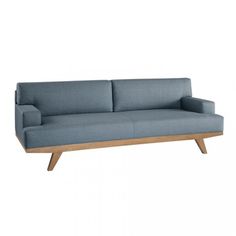 a blue couch sitting on top of a white floor next to a wooden frame and legs