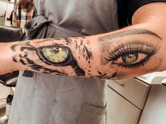 a person with a cat's eye tattoo on their arm and the other hand