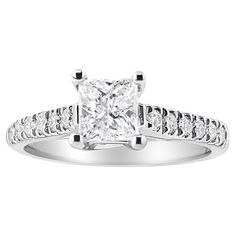 a princess cut diamond ring with channeled shoulders