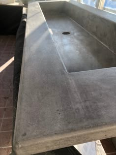 a sink that is sitting in the middle of a room with tile flooring and walls