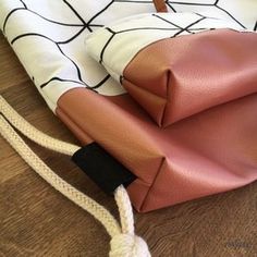 an orange and white bag on the floor next to a black and white cloth with a knot