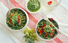 two bowls filled with pasta and pesto sauce