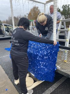 two people unloading something from the back of a truck