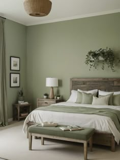 a bedroom with green walls and white linens on the bed, along with an ottoman